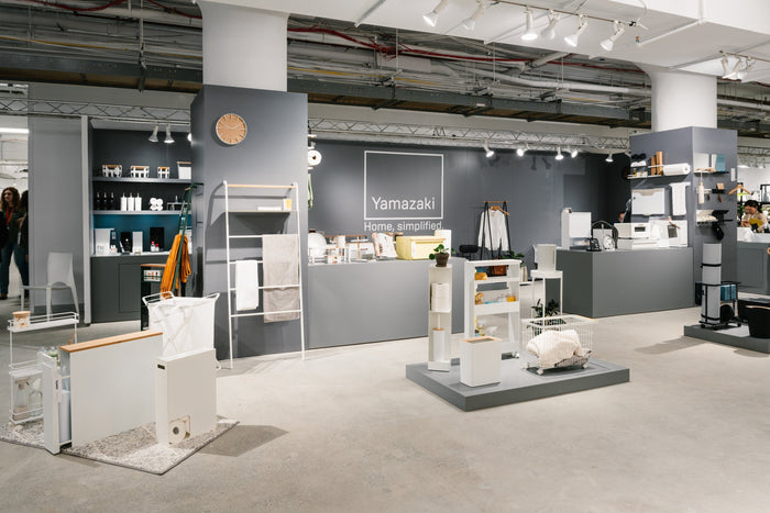 Yamazaki Home booth at Shoppe Object. Gray backdrop with white products
