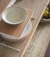 Aerial view of Dish Riser holding plates on shelf by Yamazaki Home.
