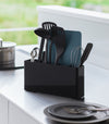Black Utensil & Thin Cutting Board Holder by Yamazaki Home on a kitchen counter, holding various utensils.