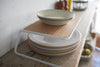 Side view of Dish Riser displaying plates on shelf by Yamazaki Home.