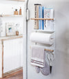 White Magnetic Organizer on kitchen fridge holding kitchen and cleaning equipment by Yamazaki Home.