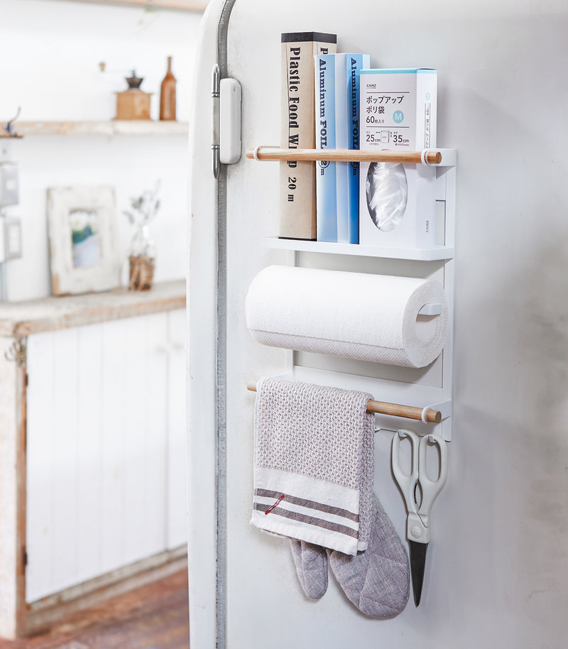 White Magnetic Organizer on kitchen fridge holding kitchen and cleaning equipment by Yamazaki Home.