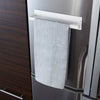 Front view of Yamazaki Home's Magnet Paper Towel Holder is seen attached to a refrigerator door with a dish towel hanging over the arm.