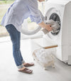 A Yamazaki Rolling Wire Basket being used to unload laundry.
