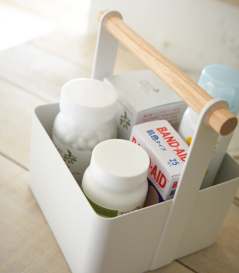 Close up aerial view of white Storage Caddy holding first aid items by Yamazaki Home.