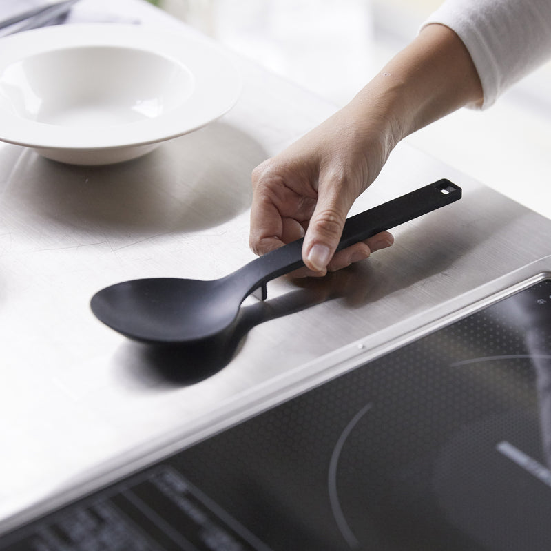 Picking up a Yamazaki Home Floating Cooking Spoon from the stove counter