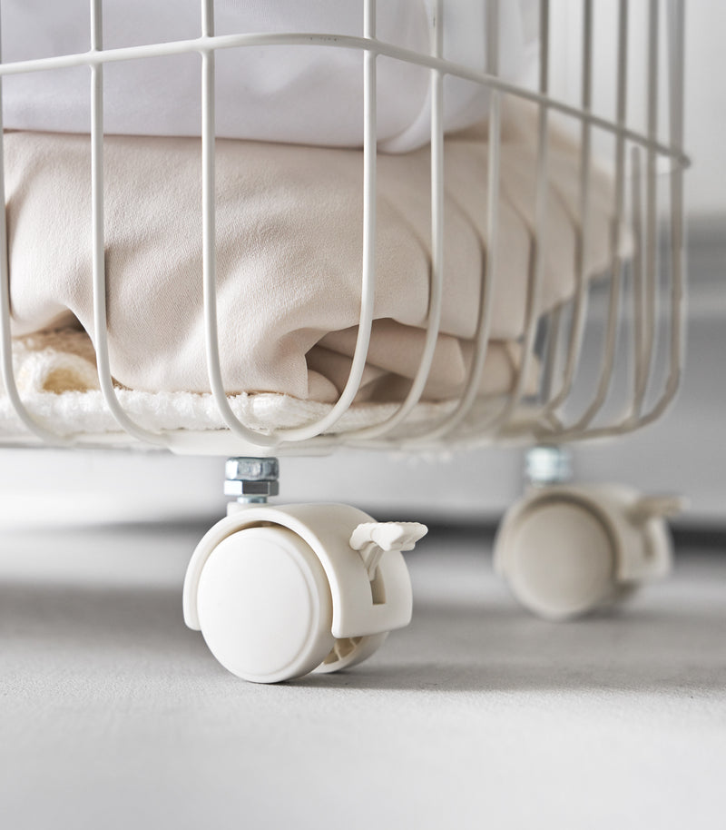 A close up of Yamazaki Rolling Wire Basket's lockable wheels.