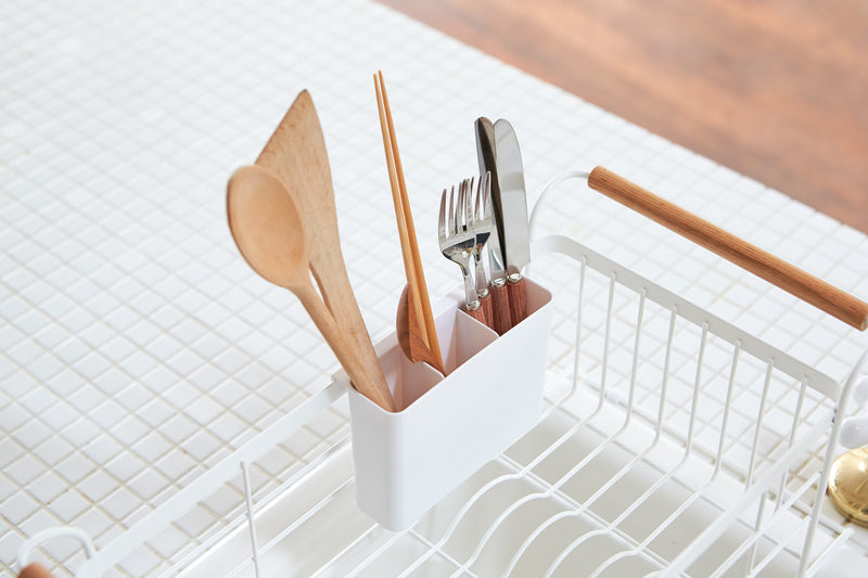White Over-the-Sink Expandable Dish Drying Rack holding silverware by Yamazaki Home.