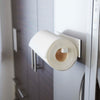 Side view of Yamazaki Home's Magnet Paper Towel Holder seen attached to a refrigerator door with a regular-sized roll of paper towels hanging on the arm.
