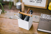 Aerial view of white Pencil Organizer holding glasses, pens, and ruler by Yamazaki Home.