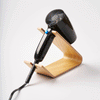 Gif of Hair Dryer and Iron Stand - Wood in Ash by Yamazaki Home holding a black hair dryer with a white background.