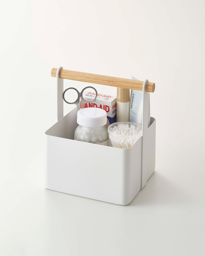 White Yamazaki toolbox small with wooden handle containing household items.