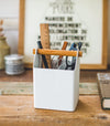 Front view of white Pencil Organizer holding glasses, rulers, and scissors by Yamazaki Home.