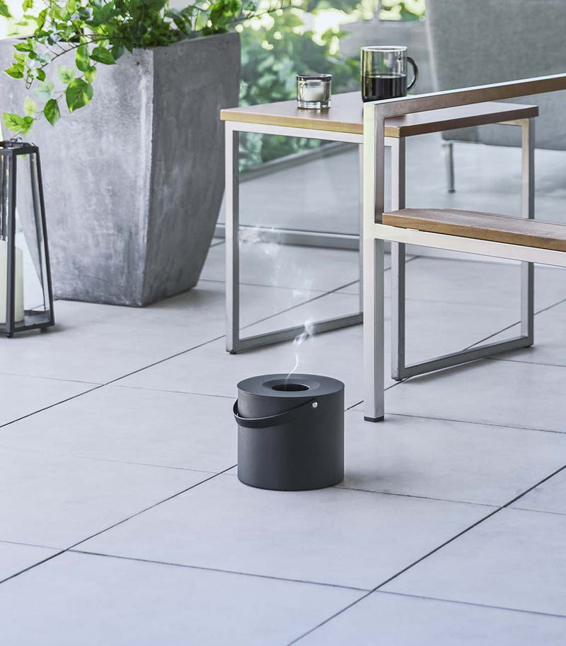 Black Yamazaki Mosquito Repellant Coil Holder and Storage Case outside on a patio