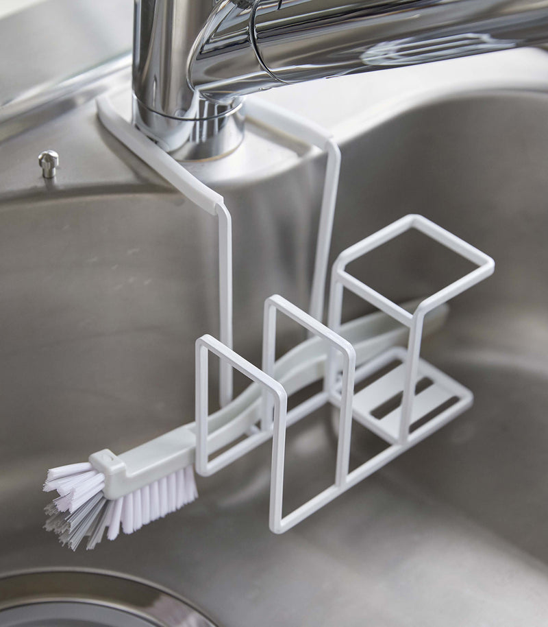 White Steel Yamazaki Home Faucet-Hanging Sponge & Brush Holder holding a brush