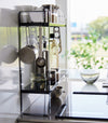 Side view of Yamazaki Home Two-Tier Countertop Rack holding spices and kitchen utensils.