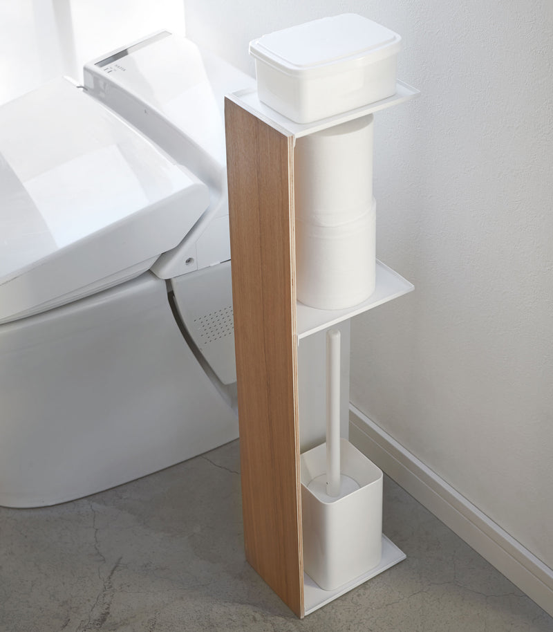 Toilet Paper Stocker holding wet wipes, toilet paper, and toilet brush in bathroom by Yamazaki Home.