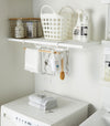 White Undershelf Hanger in laundry room holding cleaning items by Yamazaki Home.