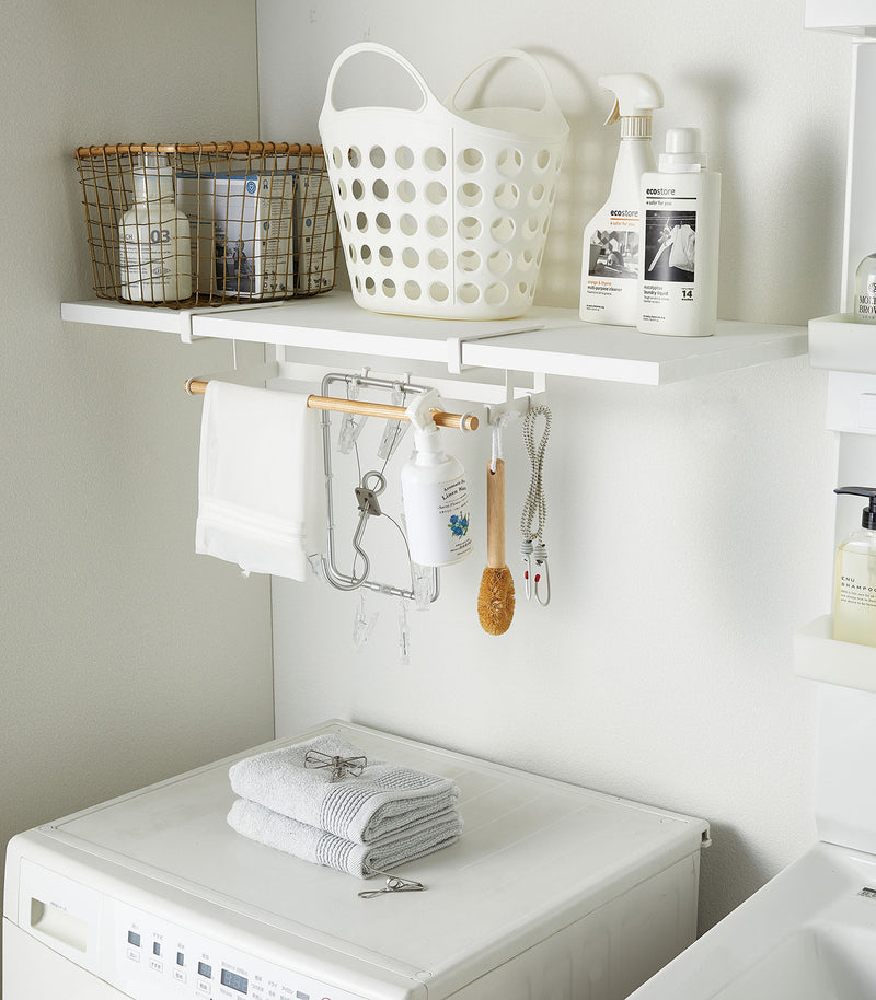 White Undershelf Hanger in laundry room holding cleaning items by Yamazaki Home.