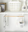 Front view of white Undershelf Hanger in laundry room by Yamazaki Home.