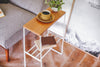 Aerial view of white End Table holding coffee cup, plant, and books by Yamazaki Home.