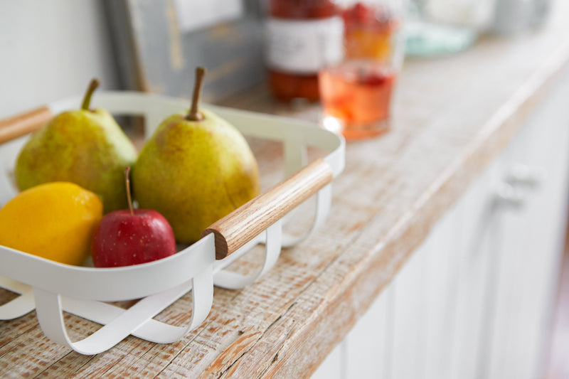 Close up view of white Fruit Bowl displaying fruit by Yamazaki Home.