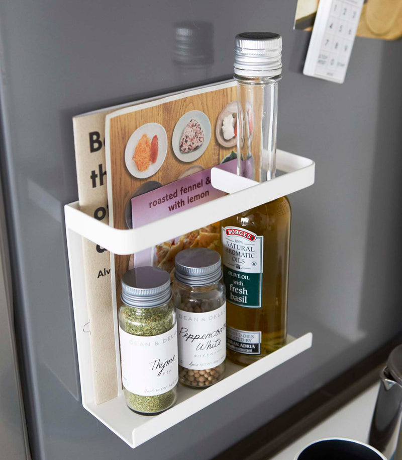 White Magnetic Wrap Holder holding books and spices by Yamazaki home.