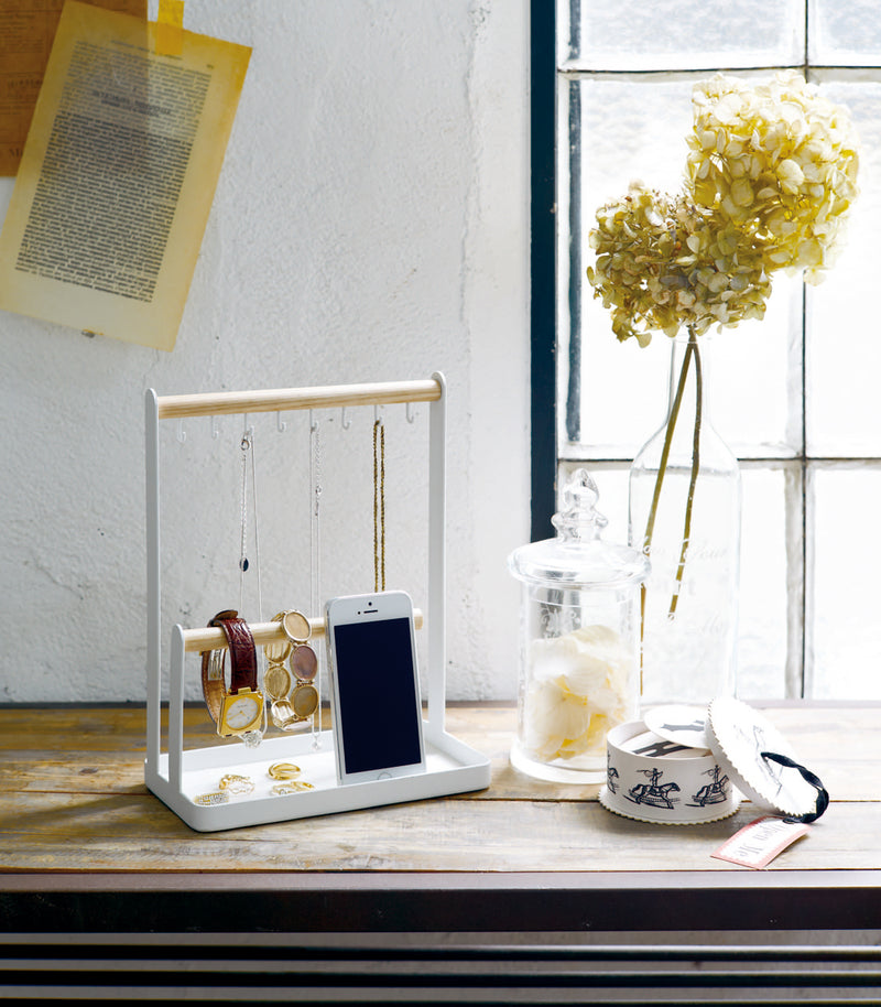 White Undershelf Organizer holding spices and dish towel by Yamazaki Home.