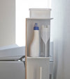 Side view of Toilet Paper Stocker holding bathroom cleaning items and accessories in bathroom by Yamazaki Home.