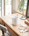 Front view of white Magnetic Organizer holding towels, spices, and cookbook by Yamazaki Home.