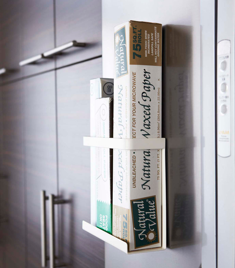 White Magnetic Wrap Holder in kitchen holding cooking wrap by Yamazaki home.