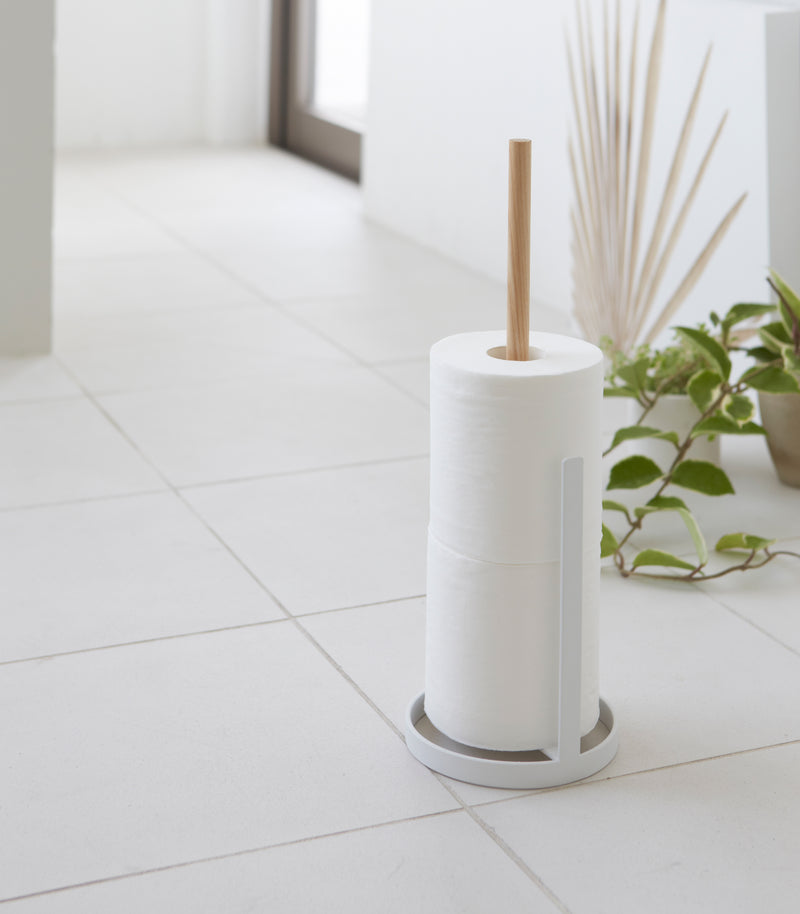 Toilet Paper Stocker holding toilet paper rolls on tile floor by Yamazaki Home.