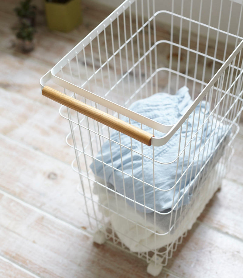 Close up view of Rolling Wire Basket holding clothes by Yamazaki Home.