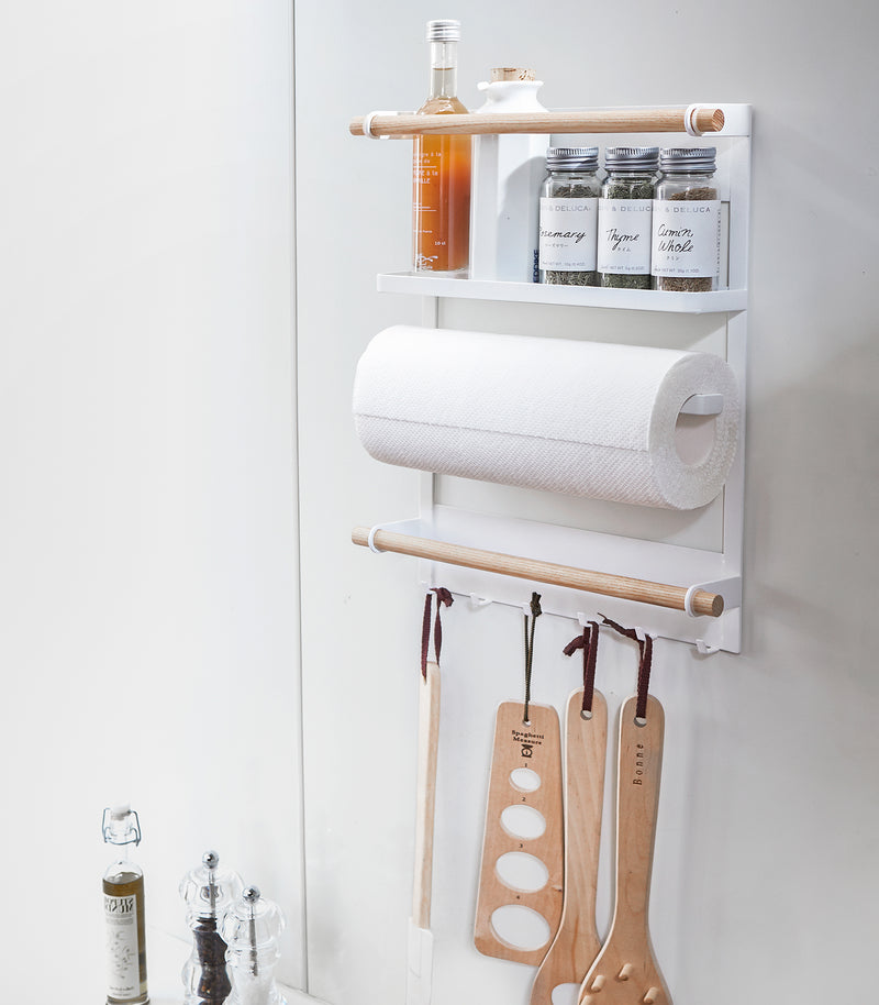 White Magnetic Organizer in kitchen holding kitchen utensils and cleaning items by Yamazaki Home.