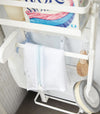 Close up front view of white Magnet Laundry Storage Pockets holding cleaning items by Yamazaki Home.
