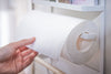 Hand removing paper towel from the Yamazaki Home Magnet Kitchen Storage Rack on a refrigerator.
