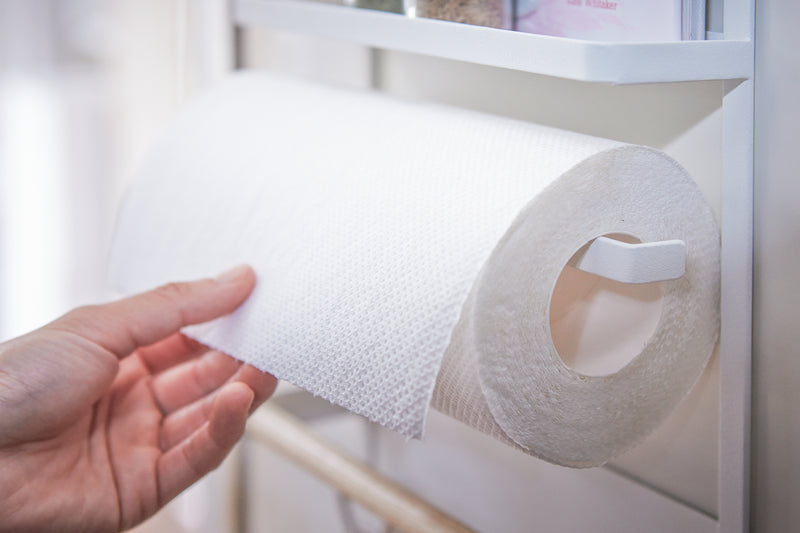 Hand removing paper towel from the Yamazaki Home Magnet Kitchen Storage Rack on a refrigerator.