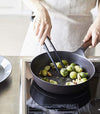 Front view of black Floating Tweezer Tongs cooking in kitchen by Yamazaki Home.