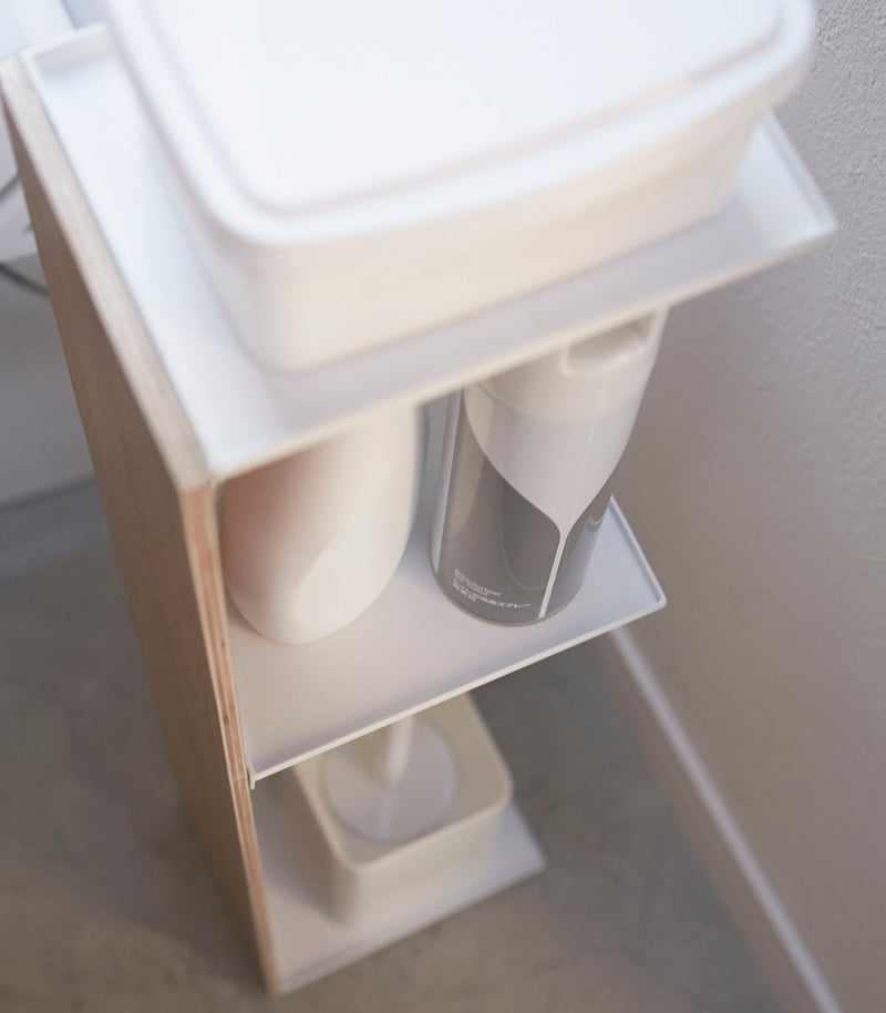 Close up aerial view of Toilet Paper Stocker holding bathroom accessories in bathroom by Yamazaki Home.