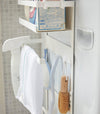 Close up side view of white Magnet Laundry Storage Pockets holding cleaning items by Yamazaki Home.