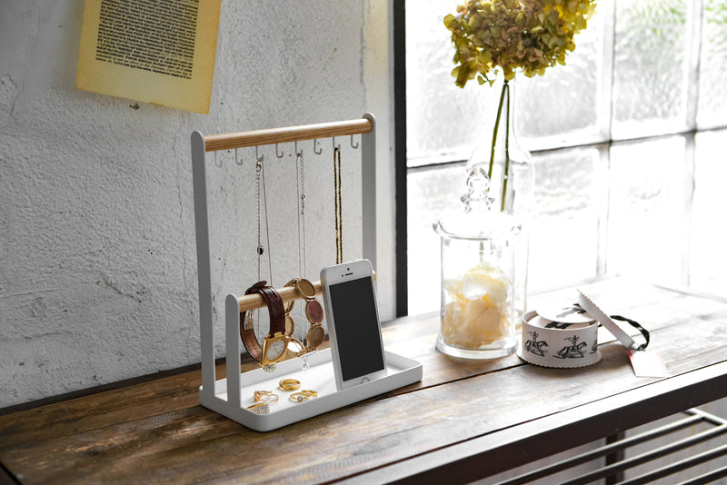 White Undershelf Hanger in laundry room holding laundry accessories by Yamazaki Home.
