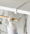 Close up of white Undershelf Hanger holding laundry supplies by Yamazaki Home.