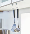 White Undershelf Hangers in kitchen holding cooking utensils by Yamazaki Home.