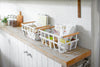 Storage Basket containing food items on shelf by Yamazaki Home.