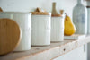 Close up side view of Ceramic Sugar Canister on kitchen shelf by Yamazaki Home.