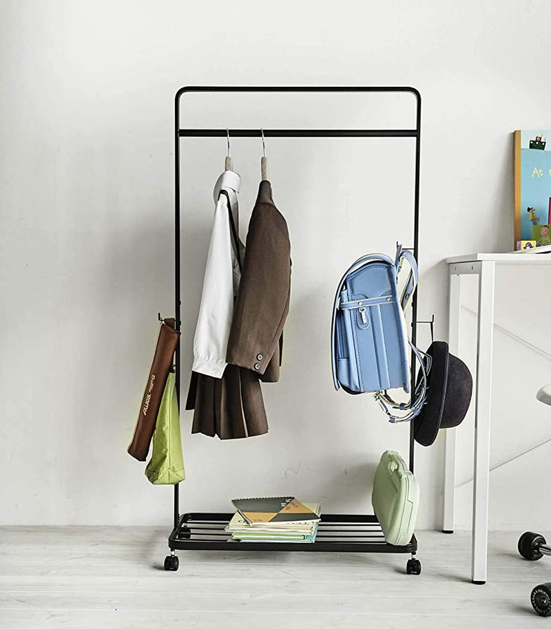 Front view of black Rolling Coat Rack holding school clothes and supplies by Yamazaki Home.