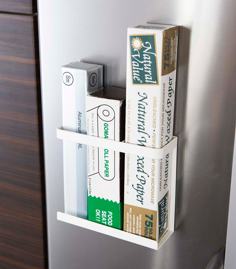 Front view of white Magnetic Wrap Holder containing cooking and baking paper by Yamazaki home.