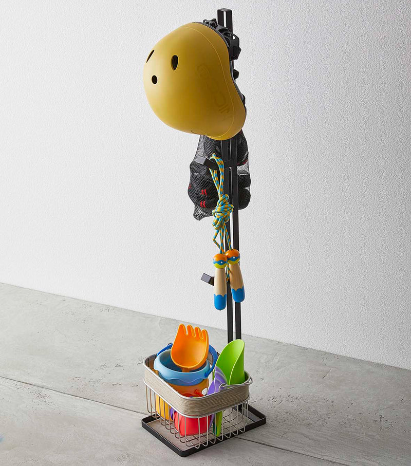 Black Kids' Helmet Stand holding a helmet and toys by Yamazaki Home.