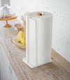 Paper Towel Holder holding paper towel on kitchen shelf by Yamazaki Home.