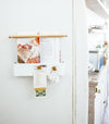 White Two-Tier Dish Rack on countertop holding dried dishware by Yamazaki Home.